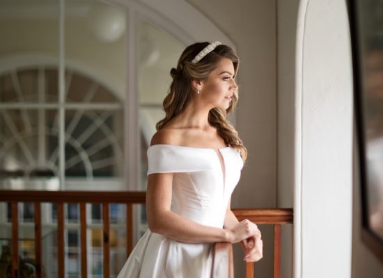 6S2A2090 Patrick bride looking out arched window with light coming through onto her