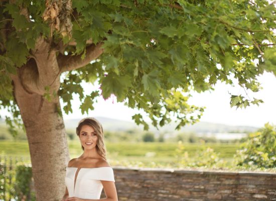 6S2A2460 Patrick bride outdoors standing under tree full of green leaves