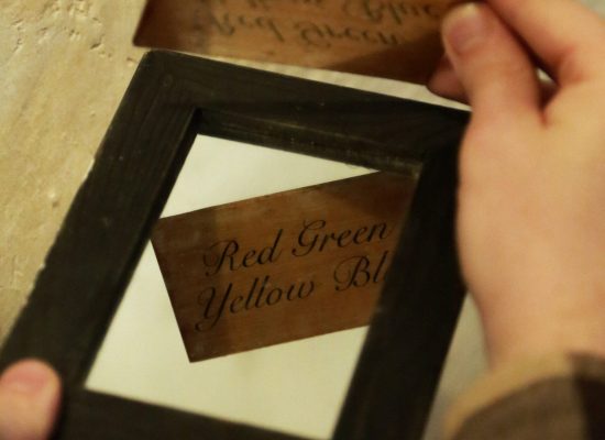 LIFFORD COURTHOUSE-34 Patrick holding small wooden block with text on it to a mirror to read the message