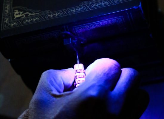 LIFFORD COURTHOUSE-72 Patrick hands twisting lock combination with blue light shining on it